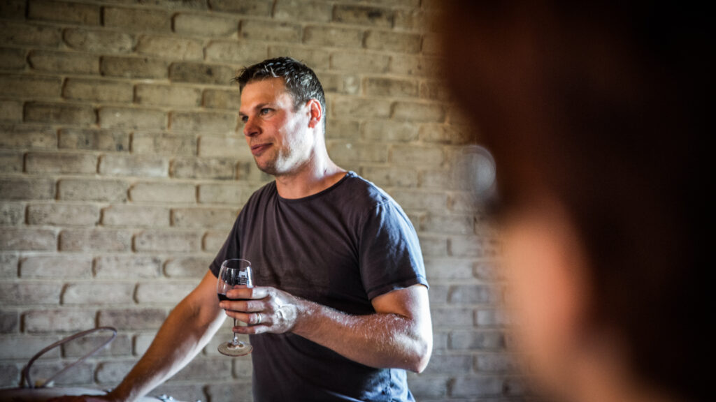 Steven Raidis in Cellar door, holding a glass of wine
